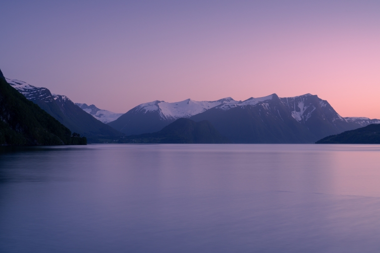 A pink and purple sunset over Romsdalsfjorden in winter